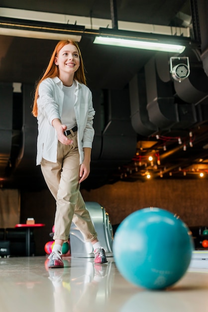 Redhead woman throwing the bowling ball