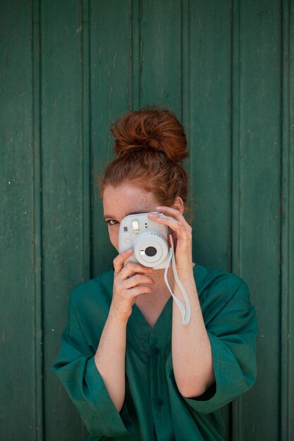 Redhead woman using a vintage camera