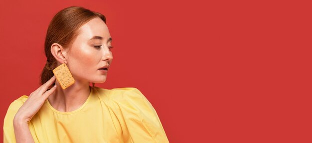 Redhead woman wearing biscuit earrings with copy space