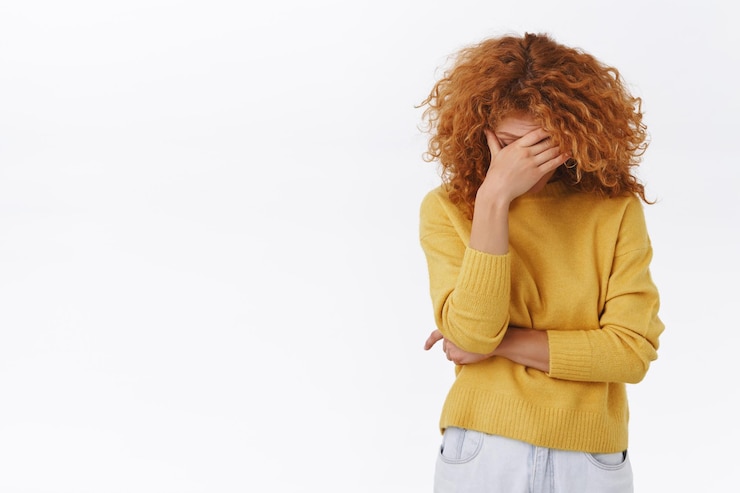 Free Photo redhead woman with curly hair in yellow sweater bending head down and closing her eyes