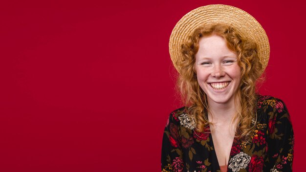 Redhead young female smiling at camera on red background