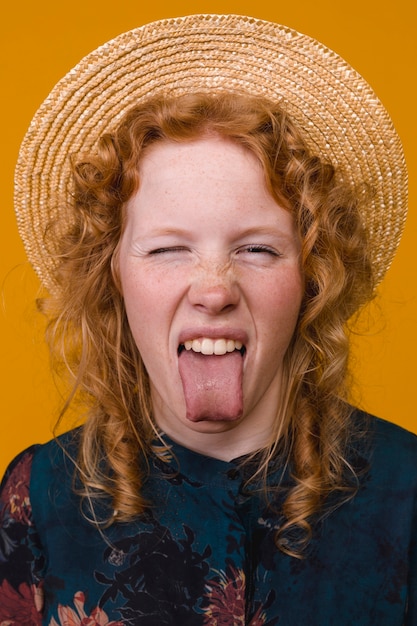 赤毛の若いそばかすの女性示す舌