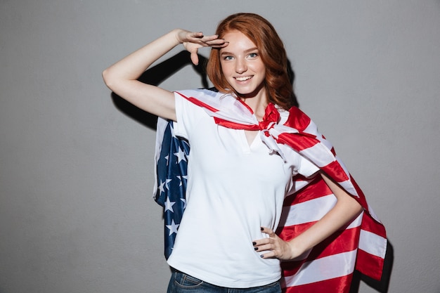Рыжая молодая леди супергероя с флагом США.