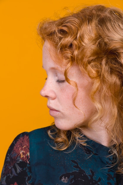Redhead young woman turning away with closed eyes