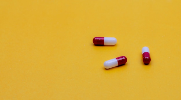 Redwhite capsule pills on yellow background pharmacy web banner prescription drug pharmacy