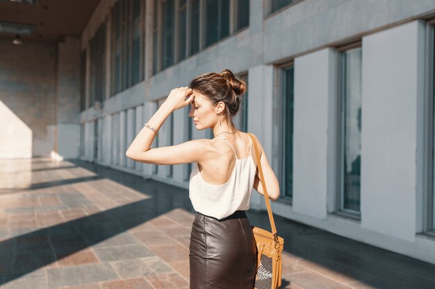 Refined young woman in leather skirt and silk blouse thinking how to solve a situation.