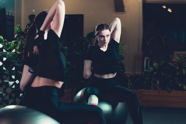 Отражение упражнения женщины на зеркале в тренажерном зале
