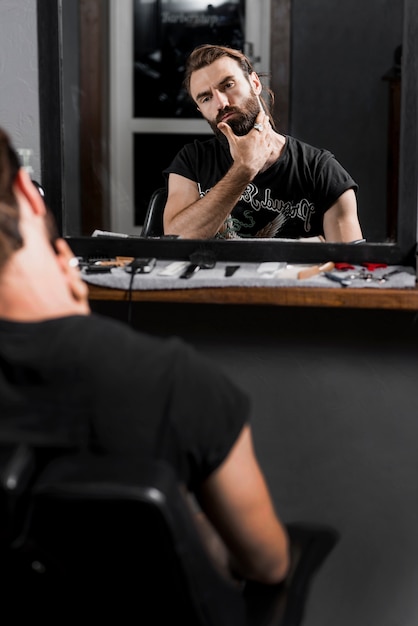 Reflection of a man grooming his beard in mirror