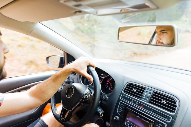 Reflection in mirror of man behind wheel