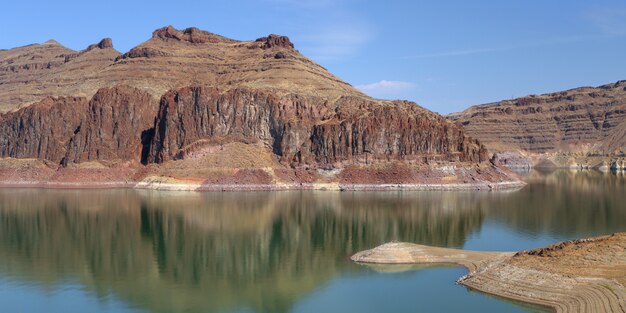 reflection of the rocky cliffs in the lake under the blue sky