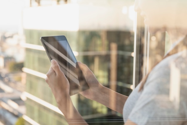 Reflection on window of person using tablet