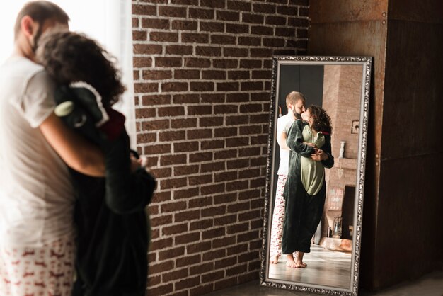 Reflection of young couple kissing in the long rectangular mirror