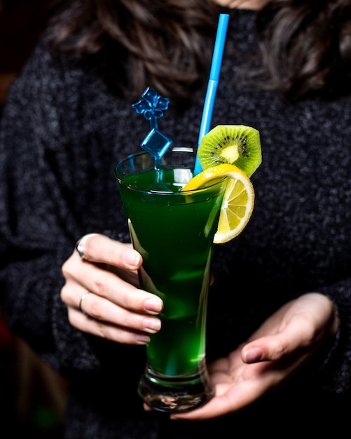 Refreshing cocktail decorated with lemon and kiwi slices