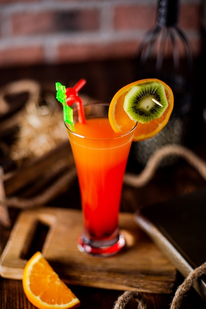 Refreshing cocktail decorated with orange and kiwi slices