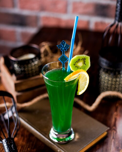 Refreshing cocktail decorated with orange and kiwi slices