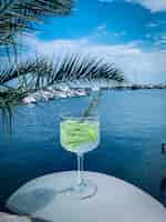 Foto gratuita cocktail rinfrescante al lime con il mare