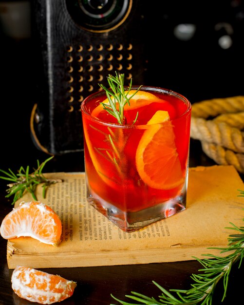 Refreshing cocktail with slices of lemon and rosemary sprig