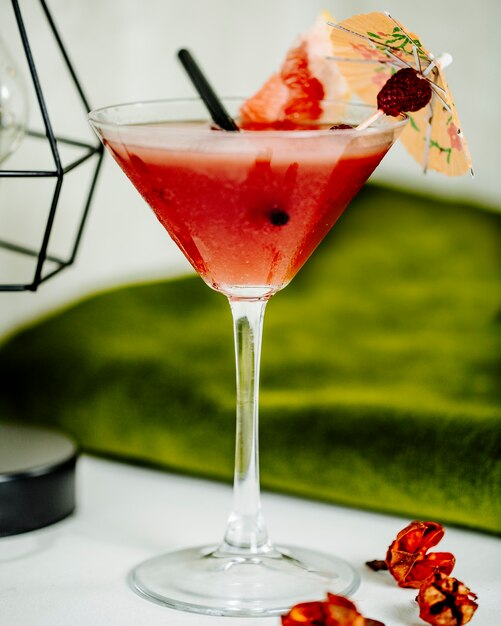 Refreshing watermelon cocktail in a glass with a piece of fruit and decorative umbrella. 