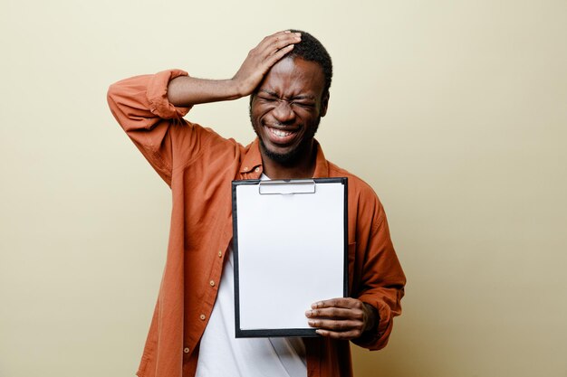 Regret putting hand on head young african american male holding clipboard isolated on white background