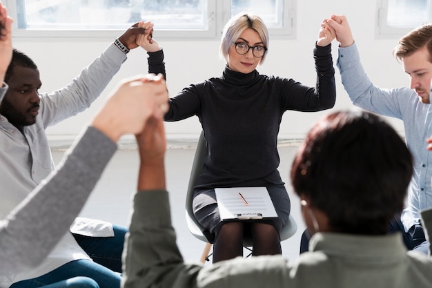 Rehab doctor raising hands with patients