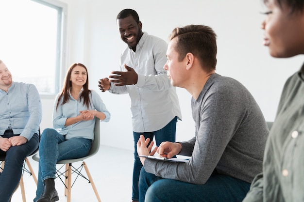 Rehab patients listening to smiling man