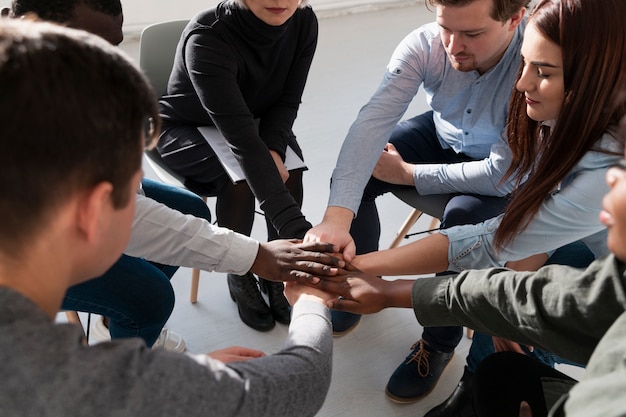 Pazienti di riabilitazione che uniscono le mani