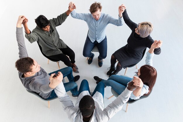 Rehab patients standing in circle and raising hands