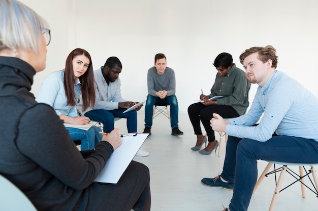 Rehab patients writing and looking at doctor