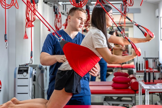 Foto gratuita specialista della riabilitazione che esegue il trattamento sulle cinghie di sospensione del paziente