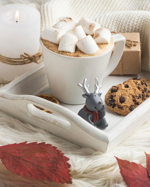 Foto gratuita statuetta di renna con tazza di cioccolata calda e presente sul vassoio