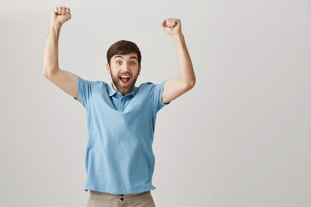 Rejoicing happy young bearded man posing