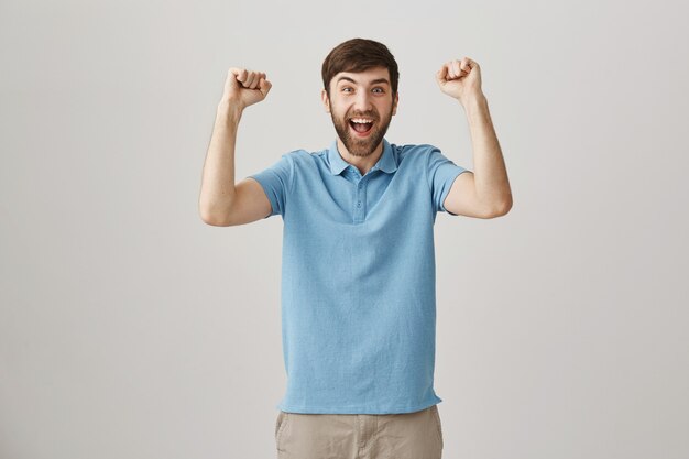 Rejoicing young bearded man posing