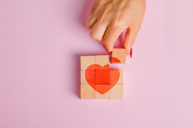 Relationship concept flat lay. finger pulling out wooden block.