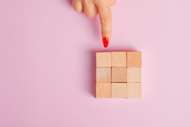 Relationship concept flat lay. finger showing wooden toy blocks.