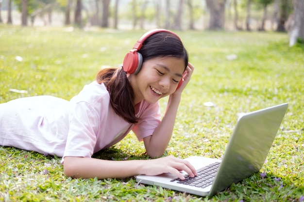 Relax and listen music concept. Girl with wireless headphones listens to the music in park.
