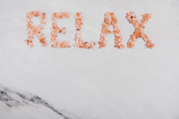 Relax word made with himalayan salt on textured background