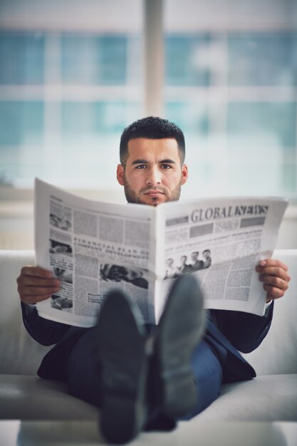 Relaxed businessman reading the newspaper