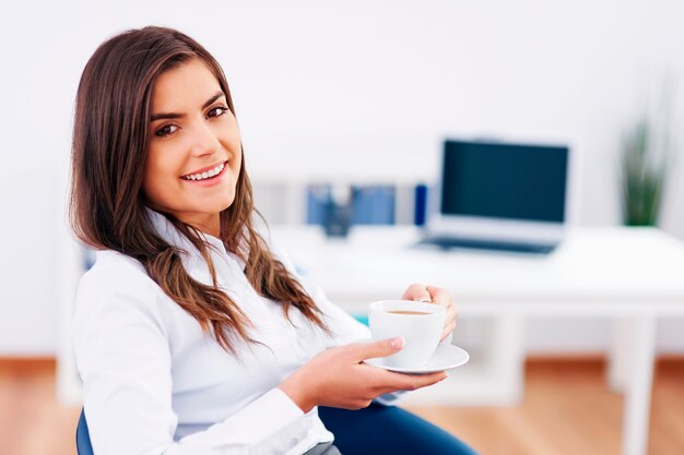 Расслабленная деловая женщина, перерыв и пить кофе