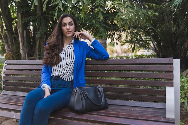 Relaxed businesswoman sitting on a park bench