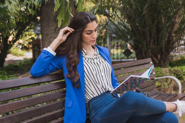 Relaxed businesswoman touching her hair while reading a notebook