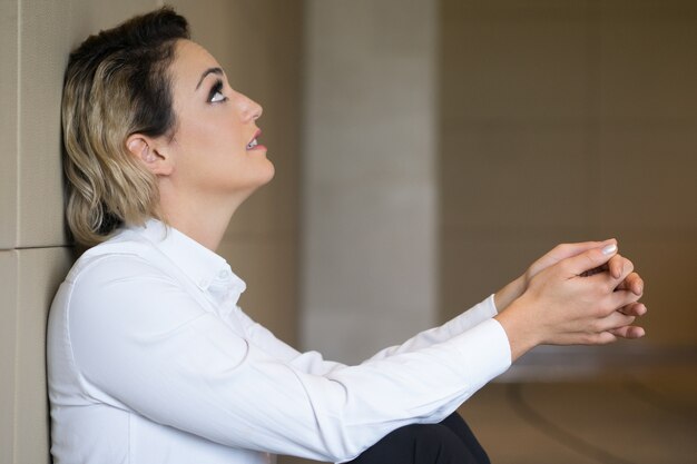 Free photo relaxed content middle-aged woman sitting on floor