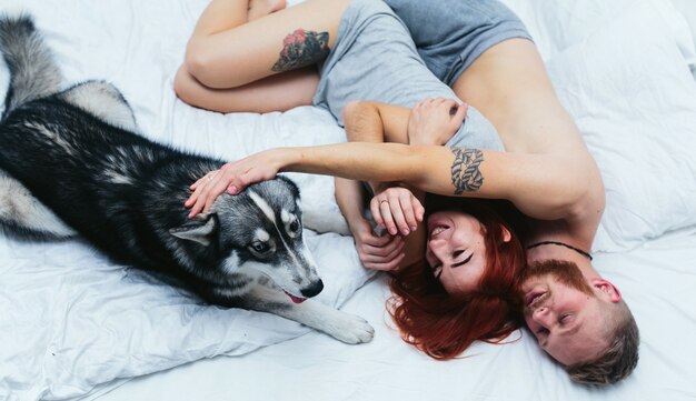 Relaxed couple in bed with their pet