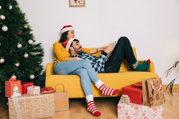 Бесплатное фото Расслабленной пара празднования рождества на диване