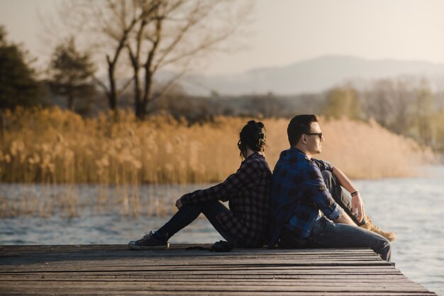 Relaxed couple sitting on planks