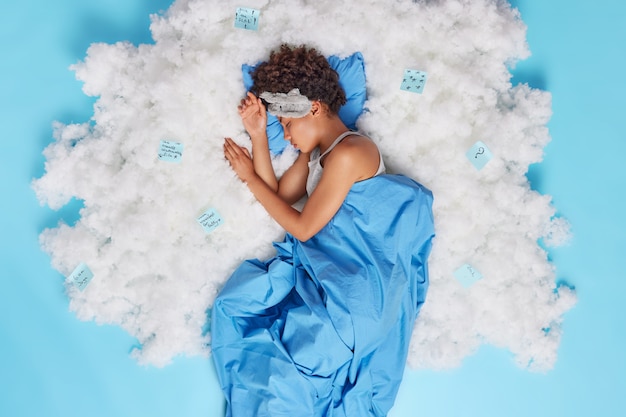 Free photo relaxed curly haired afro american woman sleeps well has sweet dreams