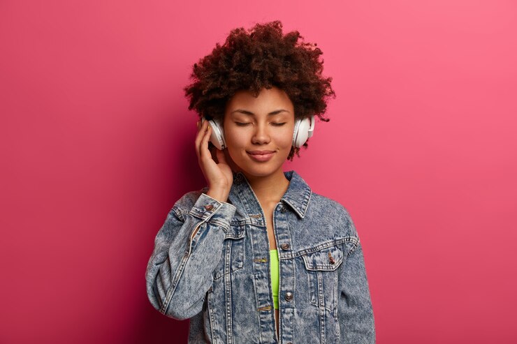 Free Photo relaxed curly woman listens music in new stereo headphones
