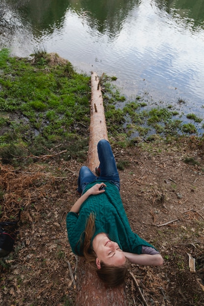 Free photo relaxed girl lying on a log