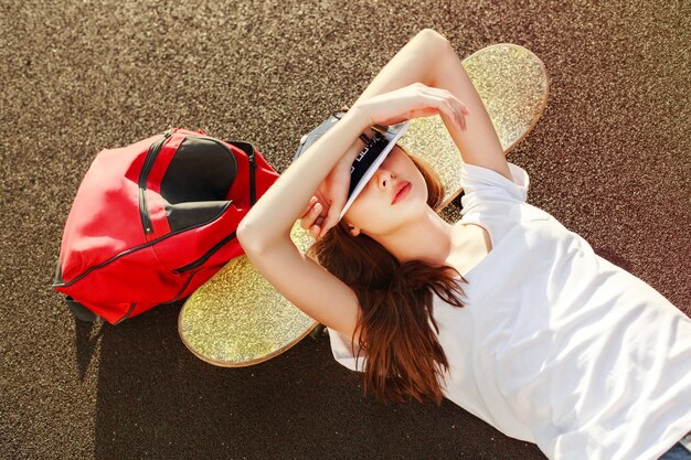 Relaxed girl with skateboard and red backpack