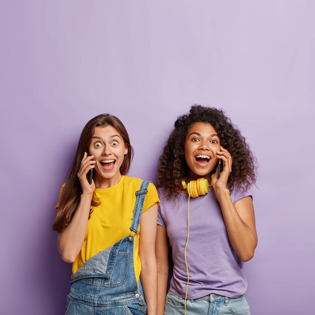 Relaxed girlfriends posing with their phones