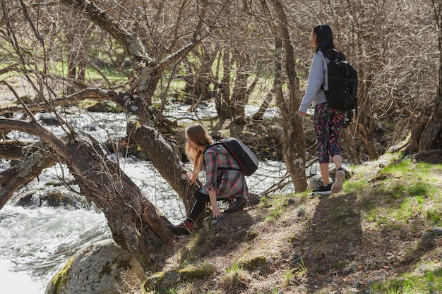 Free photo relaxed girls next to a river